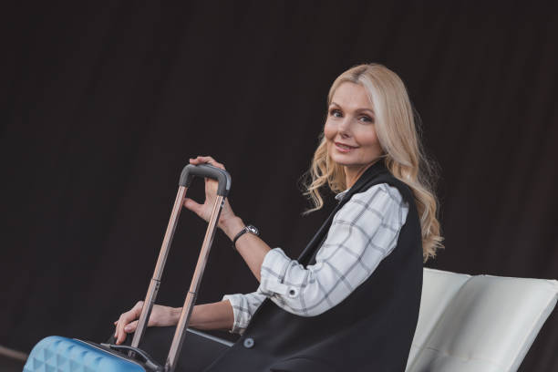 istock woman with suitcase in waiting room 907187716