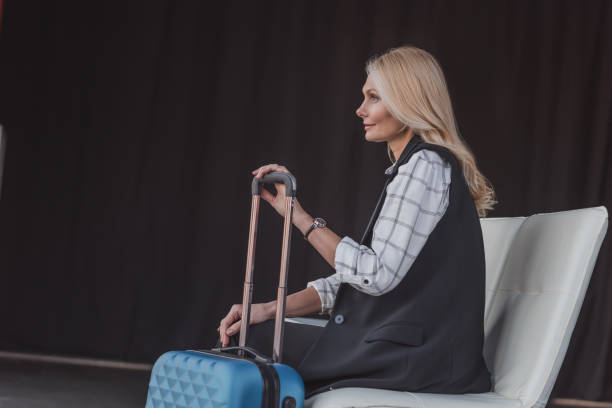 istock woman with suitcase in waiting room 907190088