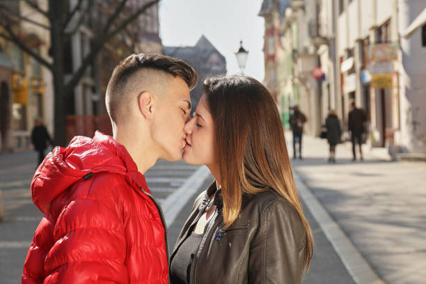 young couple kissing on the street in spring young couple kissing on the street in spring kissing on the mouth stock pictures, royalty-free photos & images