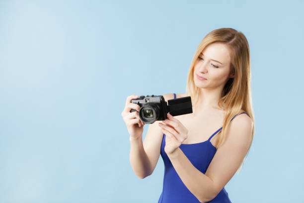 istock Blonde woman with camera on blue 907201298