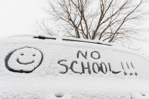 NO SCHOOL!!!  with a smiley face written in snow on car side window