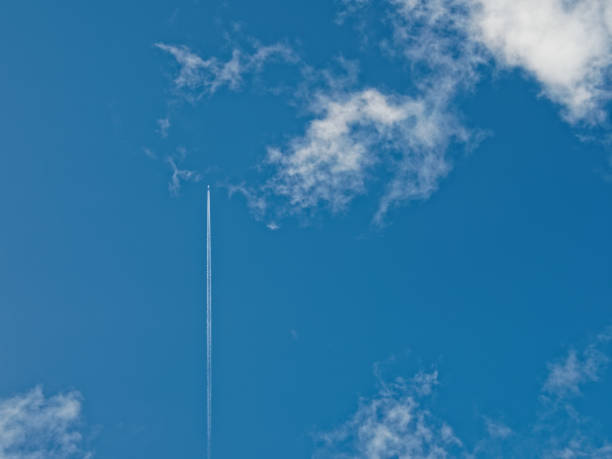 istock airplane flies between bright white clouds and blue sky 907224050
