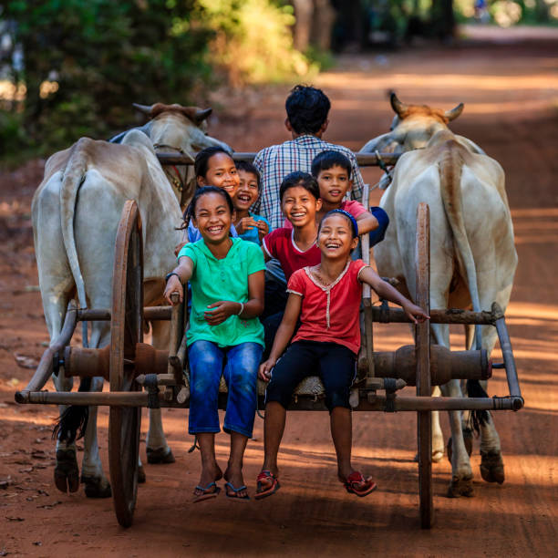 gruppo di bambini cambogiani felici che cavalcano il carro trainato da buoi, cambogia - ox cart foto e immagini stock