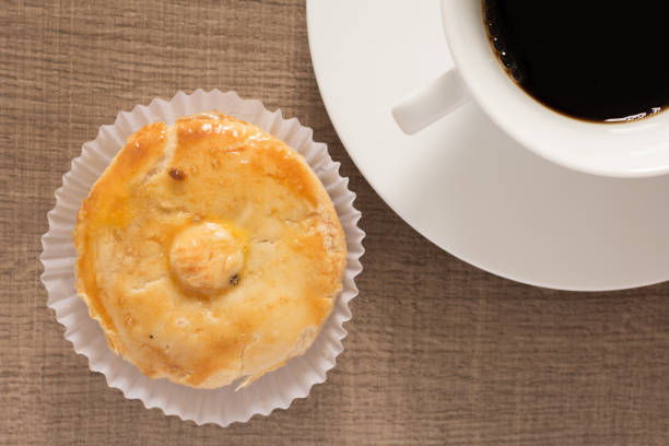 gefüllte hähnchen kuchen bekannt als empada in portugal und brasilien. snack und eine tasse kaffee auf holz, overhead. - empada stock-fotos und bilder