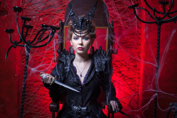 istock Woman in black holds a dagger. 907252996
