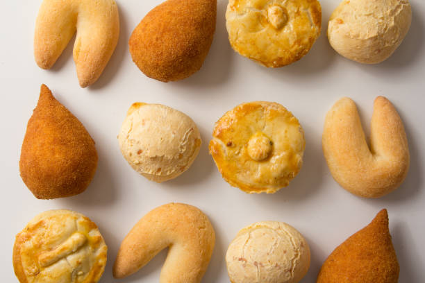 assortiment de collations : pao de queijo, chipa, coxinha et empada. parmi les plats typiques du brésil. top view, design plat laïc sur fond blanc. - empada photos et images de collection