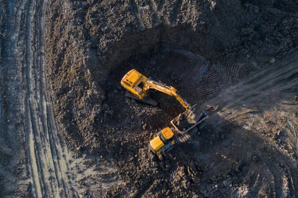 Aerial drone view of excavator loading the tipper truck Aerial drone view of excavator loading the tipper truck at the construction site bulldozer photos stock pictures, royalty-free photos & images