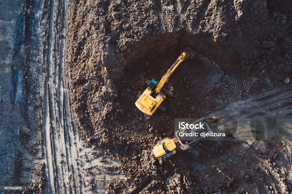 Aerial drone view of excavator loading the tipper truck Aerial drone view of excavator loading the tipper truck at the construction site Aerial View Stock Photo