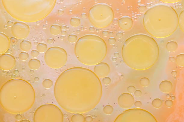 istock Drops of vegetable oil on liquid, abstract background, pop art texture, yellow circles on a light background, minimalism, pastel pattern 907268356