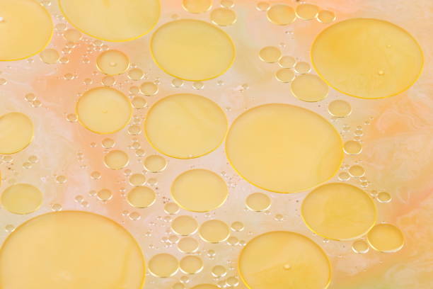 istock Drops of vegetable oil on liquid, abstract background, pop art texture, yellow circles on a light background, minimalism, pastel pattern 907268970
