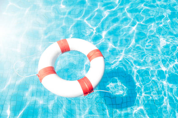 istock Lifebuoy floating on blue swimming pool. 907274102