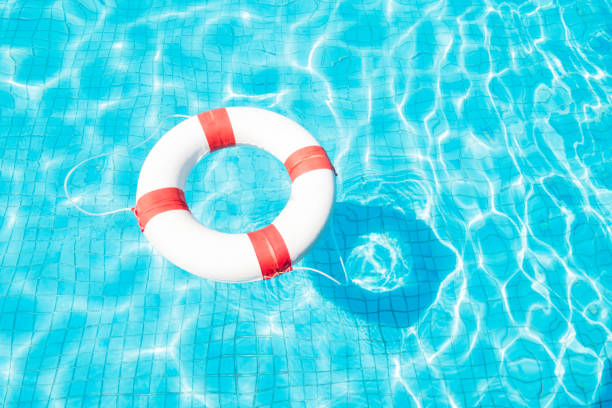 istock Lifebuoy floating on blue swimming pool. 907274122