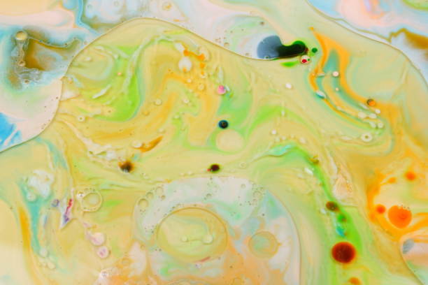 istock Multicolored oil drops on a liquid, abstract colored background, pop art texture, yellow circles with bright drops of paint, minimalism, pastel pattern 907281532