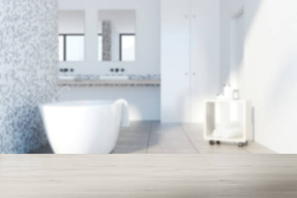 istock Gray tile bathroom, white tub blurred 907282646