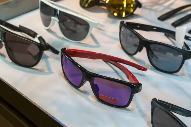 Photo of Various of sun glasses in the shop display shelves. Selective focus