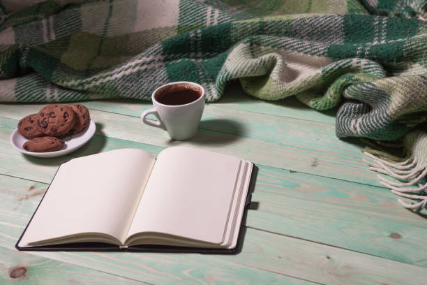 istock Cup with Hot Tea or Coffee, Warm Plaid, Book on a Wooden Table. with copy space 907317772
