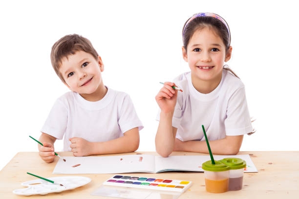 istock Two smiling kids draws with watercolor together 907329796