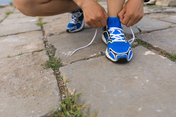istock trail running woman runner tying shoelace before run 907343064