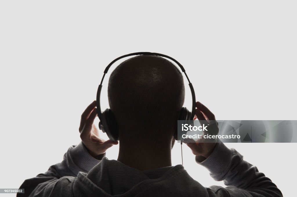 Male silhouette with hands holding headphones Male silhouette with headphones on white background. Headphones Stock Photo