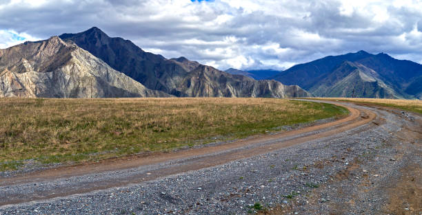 istock Mountain dirt road among the 907388438