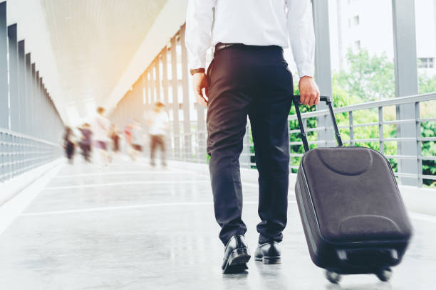 istock Businessman holding trolley bag going up on travel 907388812
