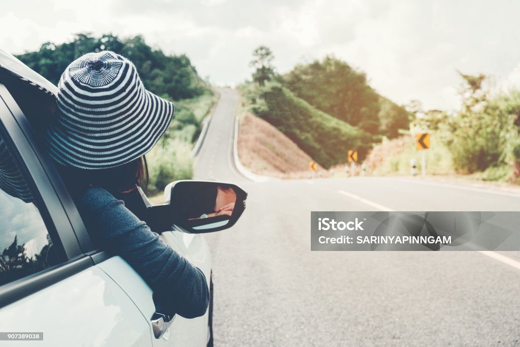 Asian woman traveler with car on Beautiful road Road Trip Stock Photo