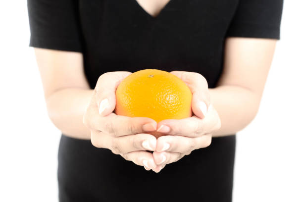 Woman Hold an Orange with Her both Hand Selective Focus White Background