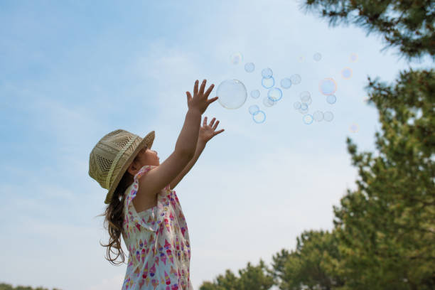 Little girl playing with soap bubbles