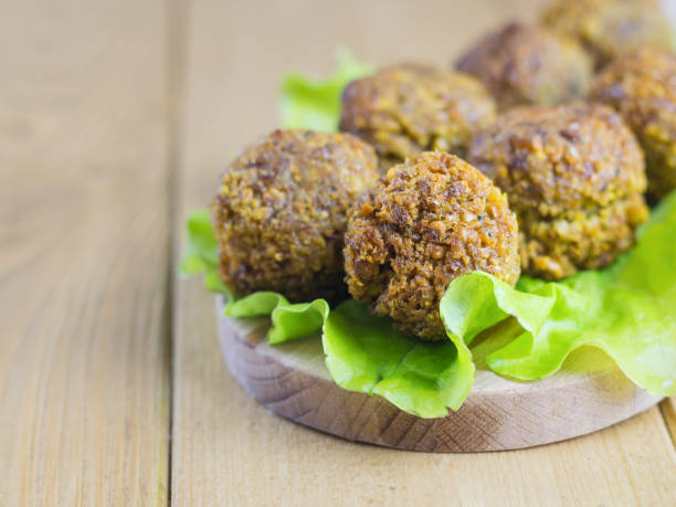 istock Freshly made falafel on a salad leaf on a cutting Board on a brown wooden table. 907437836