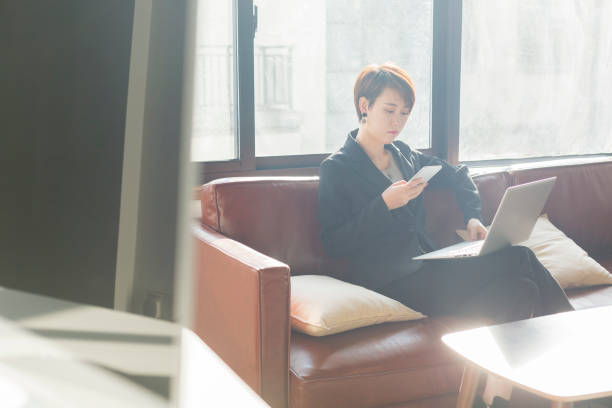 istock woman using laptop and smartphone on sofa 907453988