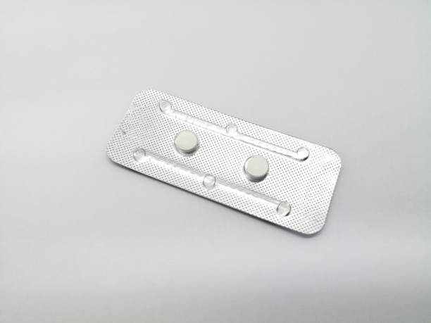 Medication concept. Oral emergency contraceptive drug. Two white pills of Levonorgestrel are in silver blister, for birth control. Abortion problem concept. Isolated on white background and copy space. Medication concept. Oral emergency contraceptive drug. Two white pills of Levonorgestrel are in silver blister, for birth control. Abortion problem concept. Isolated on white background and copy space. morning after pill stock pictures, royalty-free photos & images