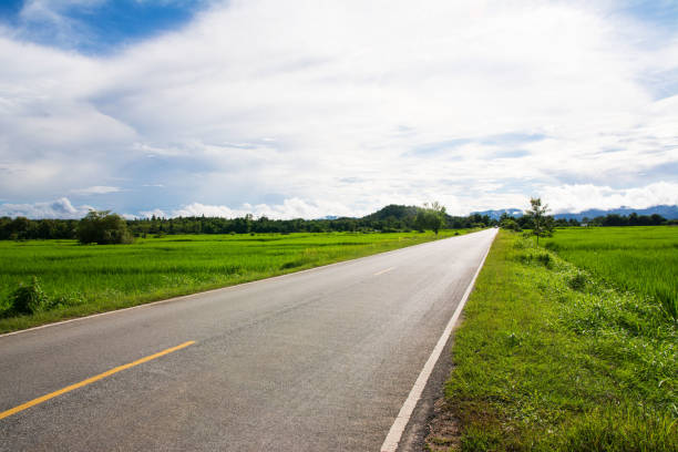 istock Asphalt Road in the field and clouds sky 907475282