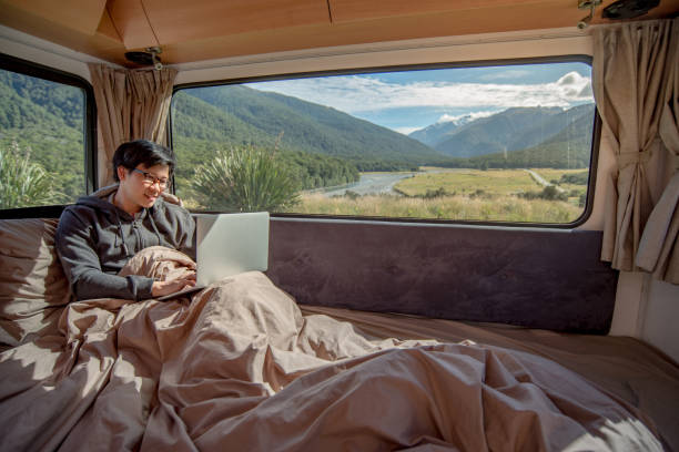 istock Young Asian man working with laptop computer on the bed in camper van 907479804