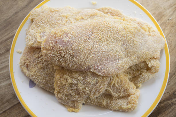 pile of breaded cutlets of chicken ready to fry