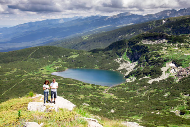 istock couple  on mountain peak taking picture 907484942