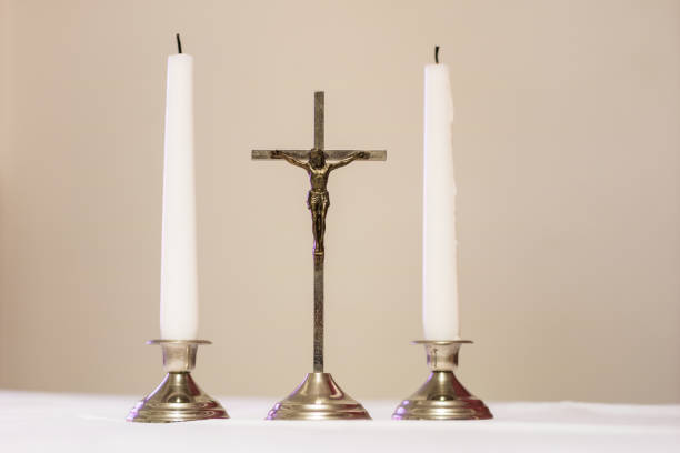 istock Cross and candles on a white tablecloth. Carol singing, cross and candles on a white table. Holiday time. 907485428