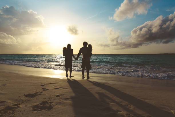 istock happy family with two kids walk on sunset beach 907491080