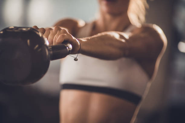 Close up of unrecognizable athlete exercising with kettle bell. Close up of unrecognizable athletic woman having sports training with kettle bell. kettlebell stock pictures, royalty-free photos & images