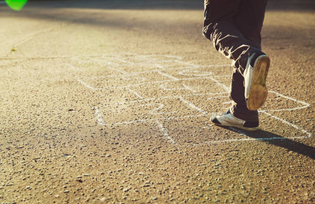 istock little boy playing hopscotch on playground 907499814