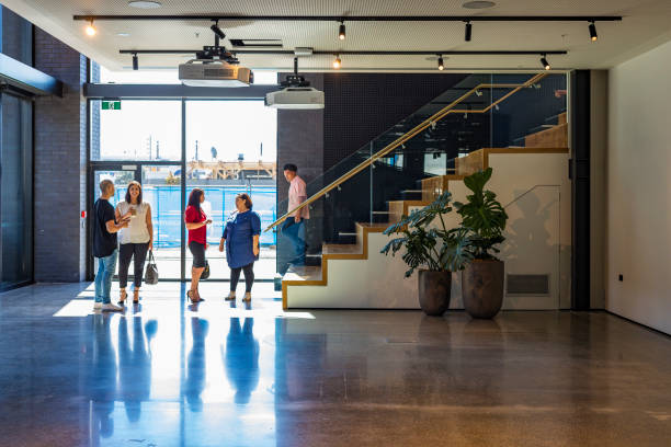 istock Backlit Business People Walking Through an Office Lobby 907504382