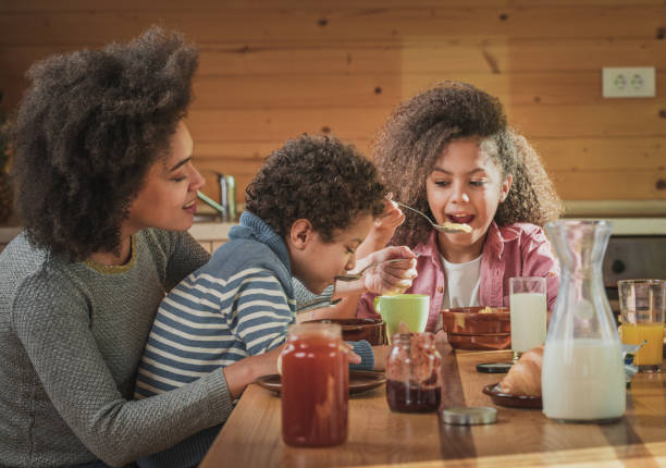 istock Happy black mother eating breakfast with her kids at dining table. 907538244