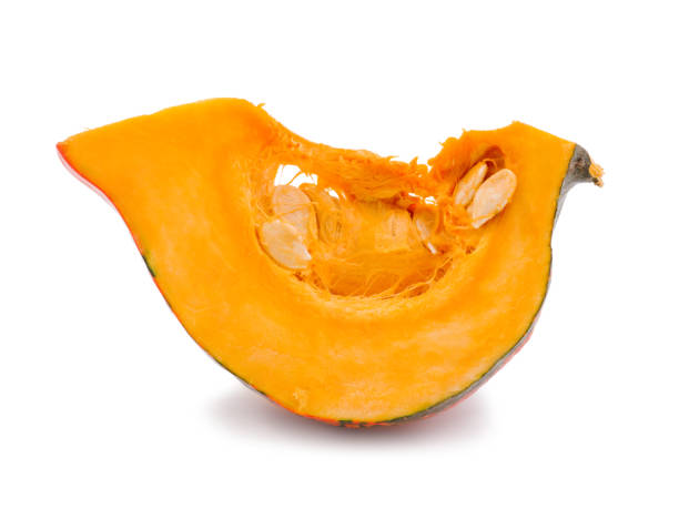 istock Piece of pumpkin with seeds inside. Isolated on white. Close-up. 907549188