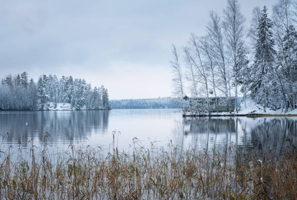 winter landscape with sauna cottage and peaceful lake at evening in finland - finland sauna lake house imagens e fotografias de stock