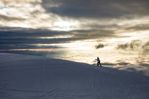 istock Silhouette of Young Skier Moving Uphill 907558856