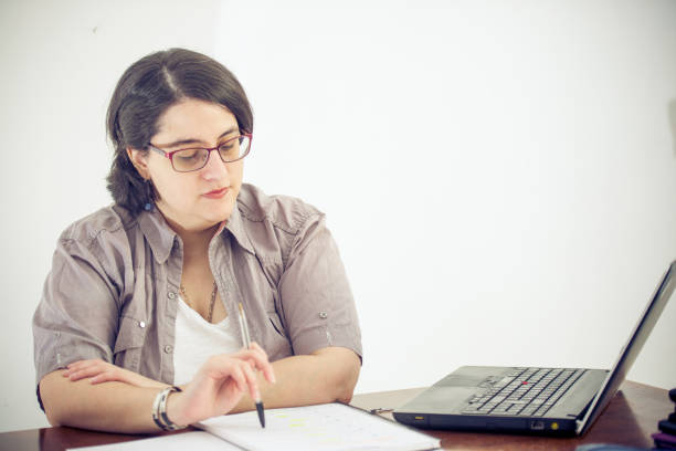 istock Adult Woman Taking Notes and Working With Laptop 907563544