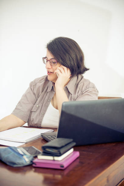 istock Adult Woman Using Mobile Phone in Office 907563578