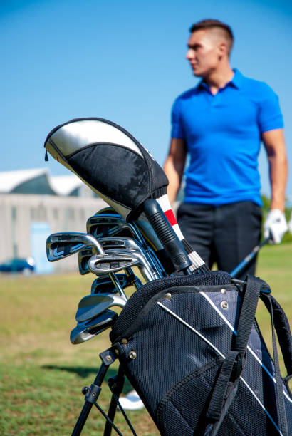 istock Golf Bag with Golfer in the Back, Focus on Foreground 907563622
