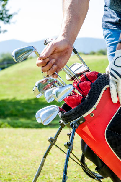 istock Golfer Pulling Out a Golf Club From the Bag 907563696