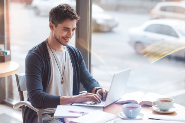 istock Handsome bearded man looking at screen of his laptop 907564732
