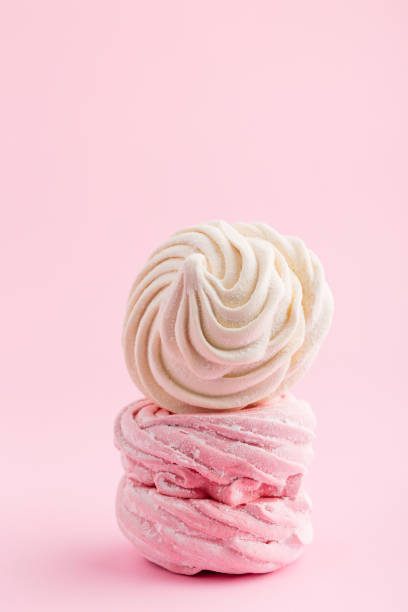 istock Homemade pink and white zephyr or marshmallow on pink background 907567512